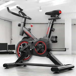 Bicicleta ergométrica spinning preta e vermelha com monitor
