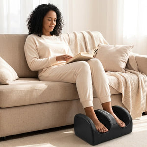 Mulher lendo um livro no sofá com os pés no massageador FootSpa™