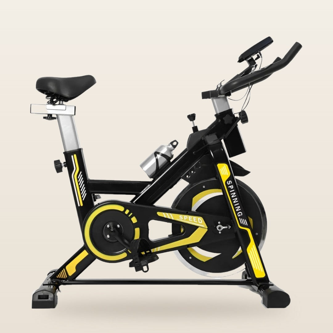 Bicicleta spinning com detalhes amarelos, suporta até 150 kg, em fundo off-white