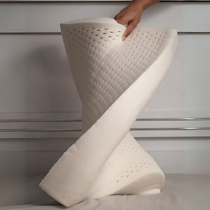 Travesseiro de látex LatexCloud sendo dobrado, mostrando a elasticidade do material