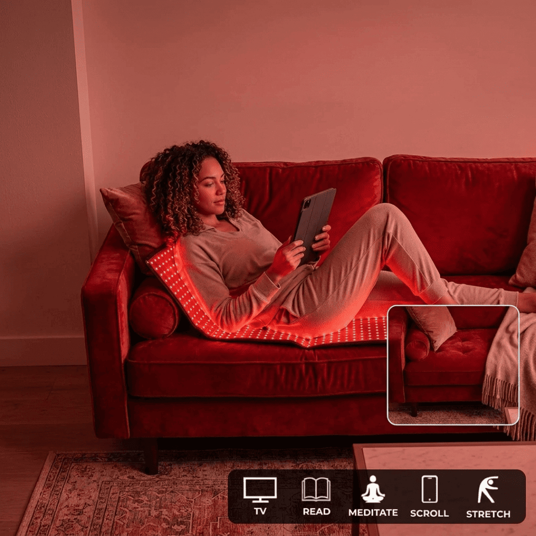 Mulher relaxando no sofá vermelho com tablet, apoiada no tapete de luz vermelha LumiCore aceso
