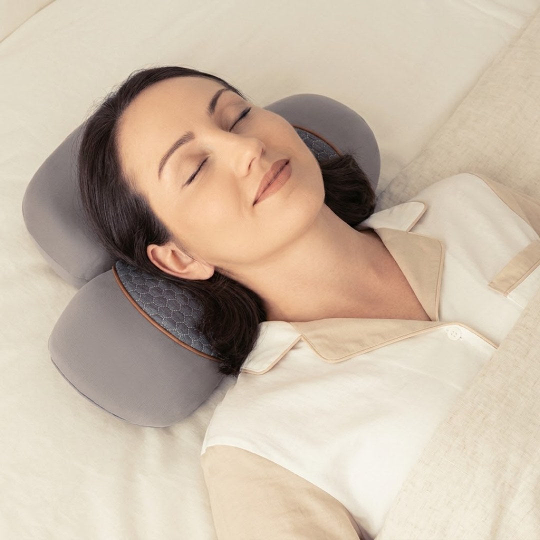 Mulher deitada de olhos fechados com a cabeça e o pescoço apoiados no NeckCalm™