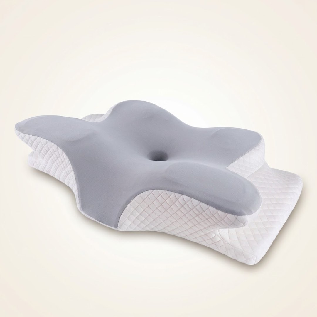 Travesseiro cervical SleepWing™ em formato borboleta, tampo cinza claro e base branca em losangos